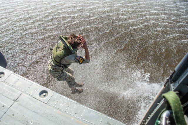 A Soldier with Team 40 jumps out of a helicopter into Victory Pond wearing a life jacket