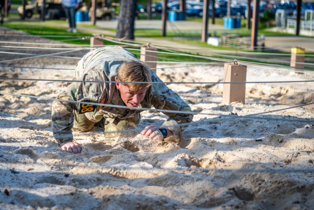 Staff Sgt. Zackery Williams, a Ranger instructor with the 4th Ranger Training Battalion, and 4th place finisher, low crawls under wire. 